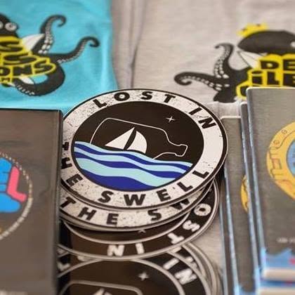 Stickers ronds Lost in the Swell empilés sur des t-shirts